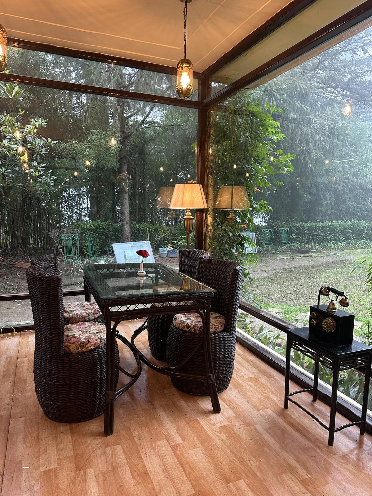Lamplit corner table at Heritage Cafe 1938 with a view of the Deodar forest