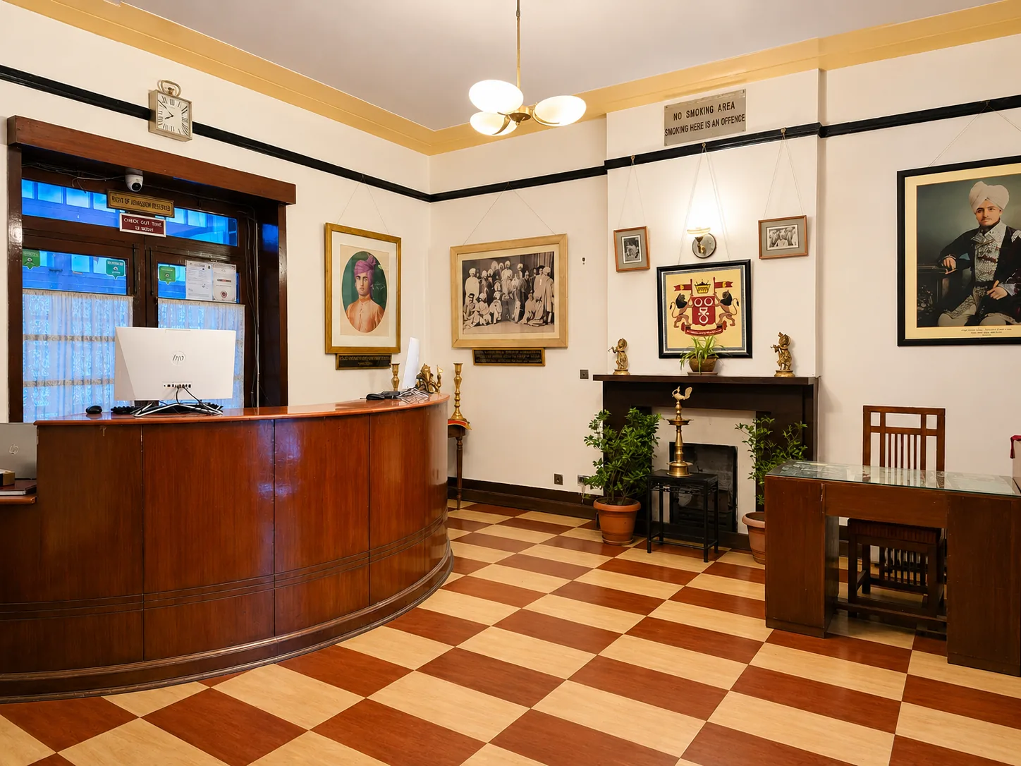 Reception hall with wood panelling, chequered floor and portraits of the royal family