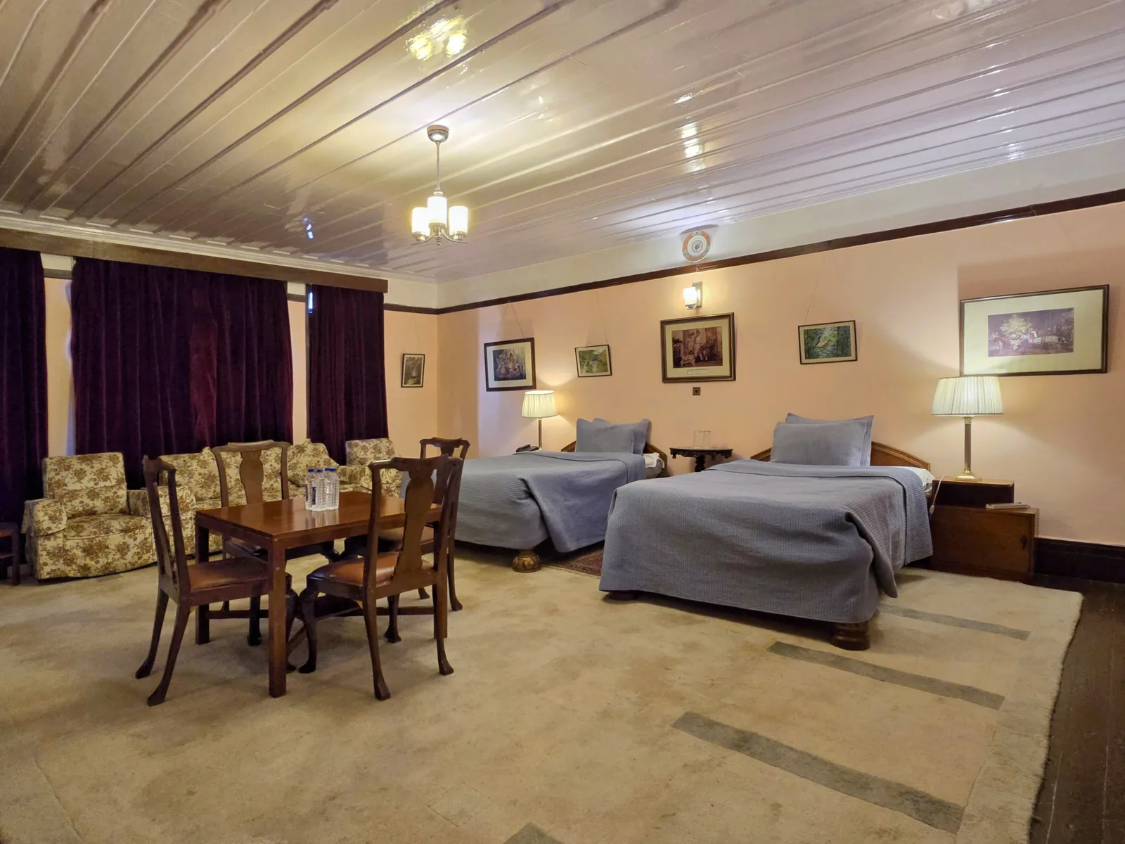 Heritage Bollywood Suite twin bedroom with a dining table and floral armchairs