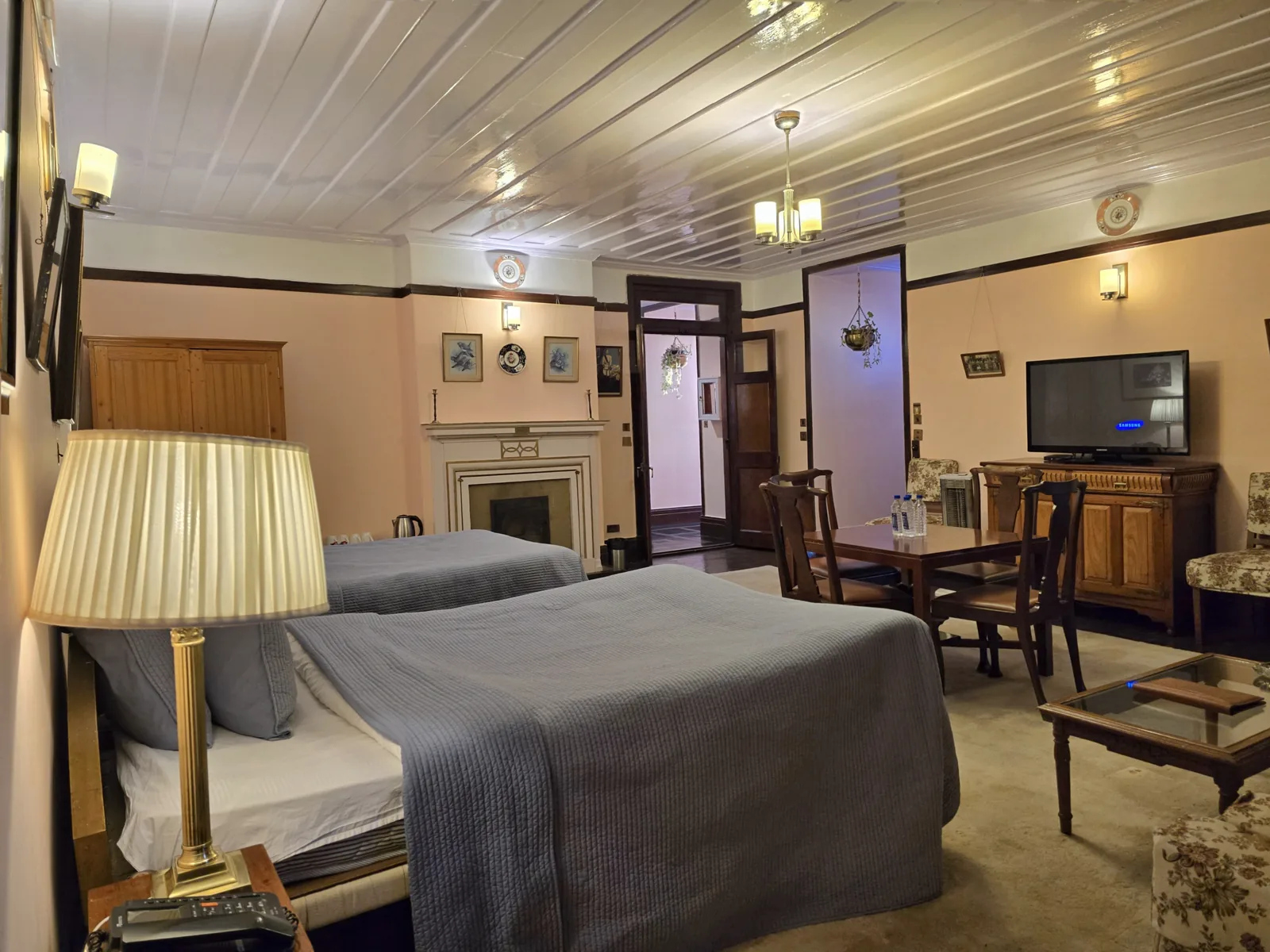 Heritage Bollywood Suite twin bedroom with a brass lamp, fireplace and television