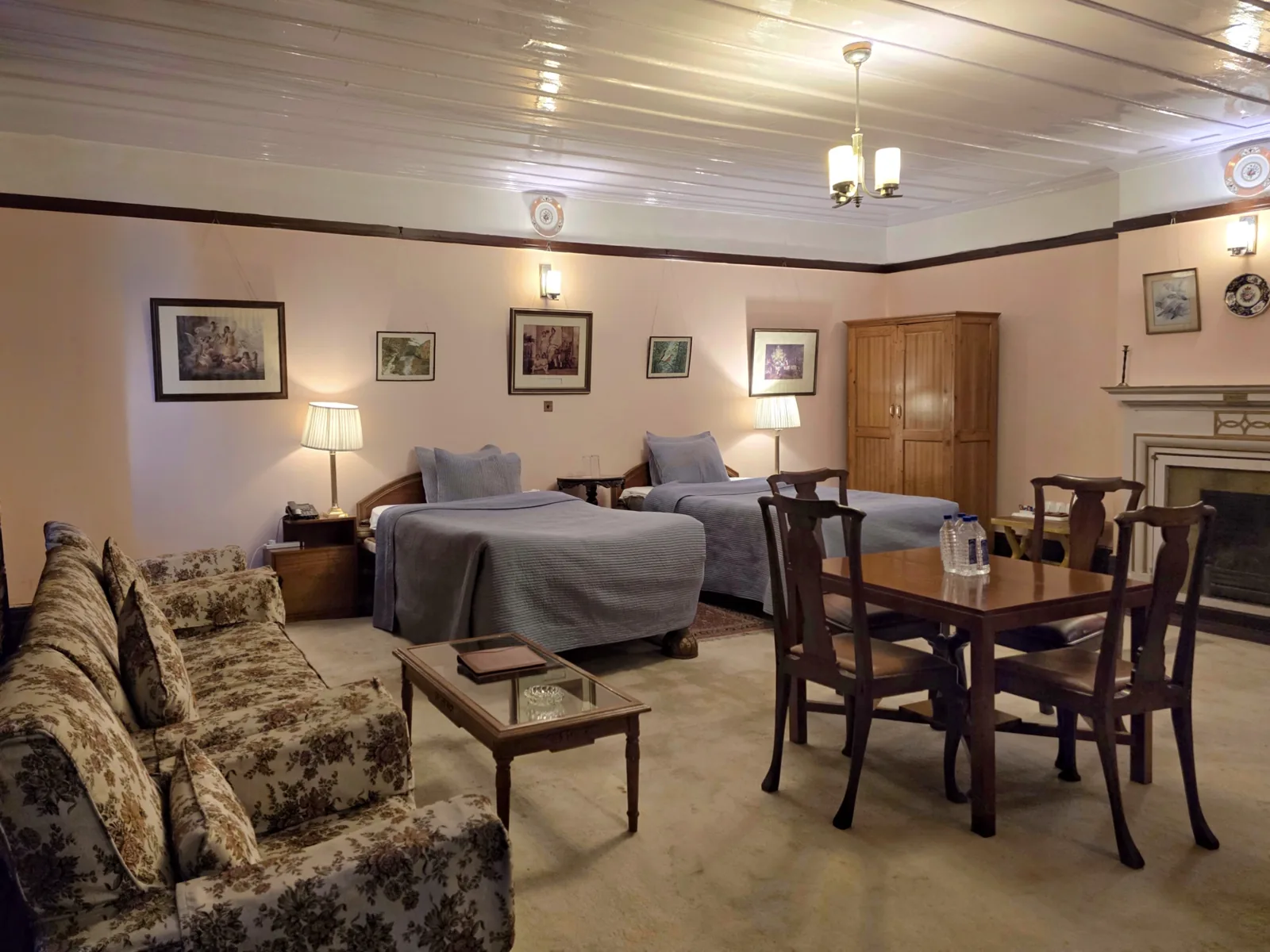 Heritage Bollywood Suite sitting area with a sofa, writing table and twin beds beyond