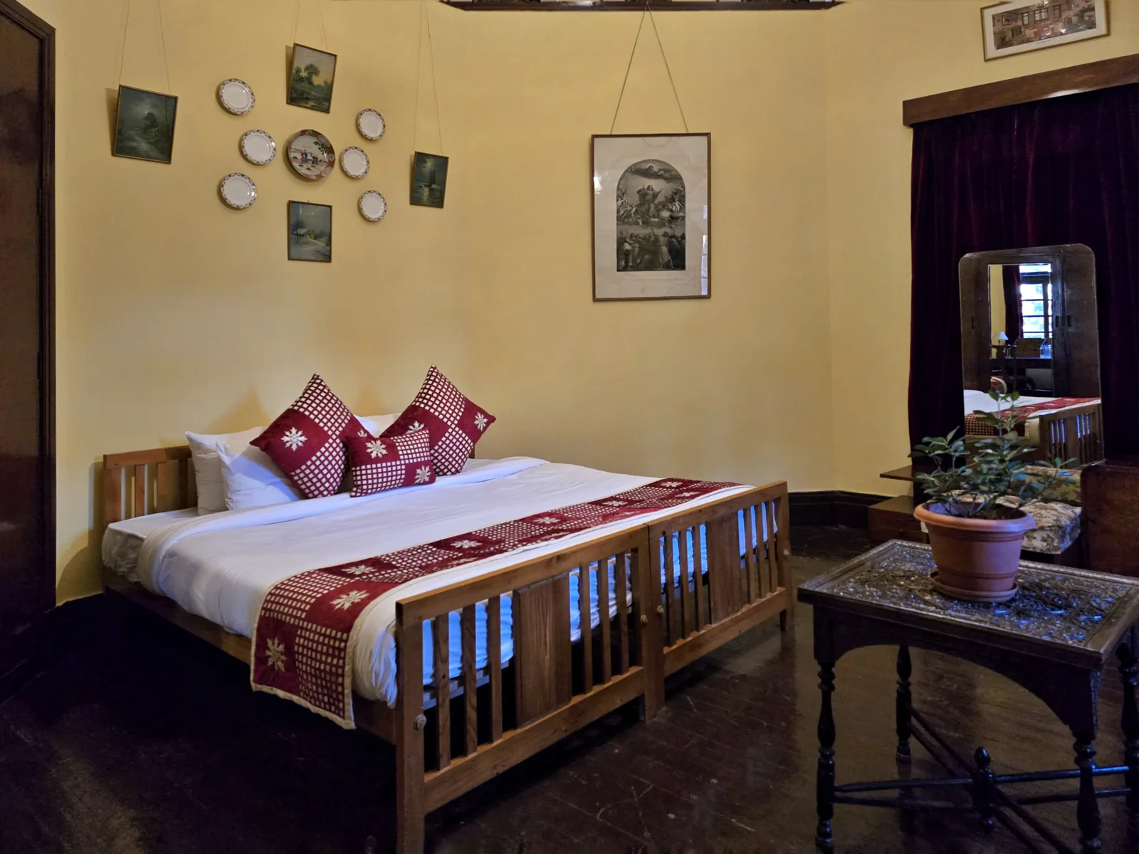Heritage Bollywood Suite double bedroom from another angle, with framed prints and a red velvet curtain
